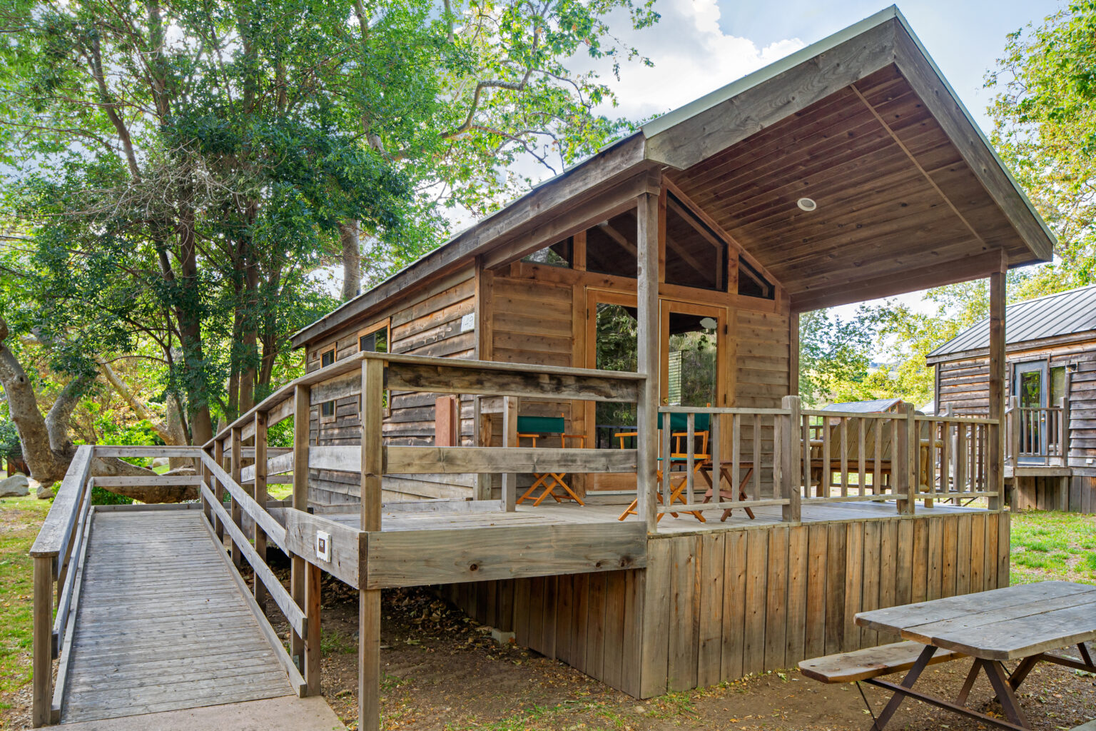 image Settle into a charming, nature-inspired cabin with a spacious deck, perfect for soaking in the peaceful surroundings.