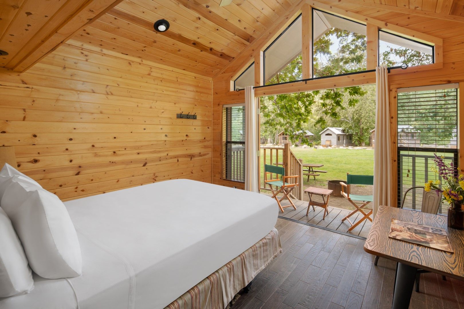image Wake up to serene views and fresh air in a bright, open bedroom with floor-to-ceiling windows and a private deck.