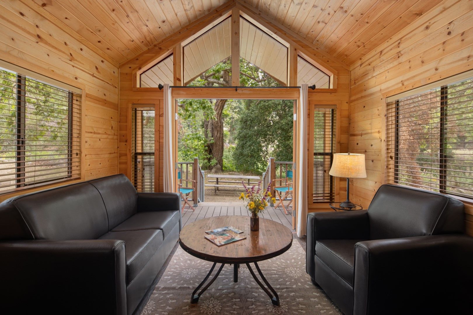 image Unwind in a bright and airy living space, where vaulted ceilings and large windows bring the beauty of nature indoors.