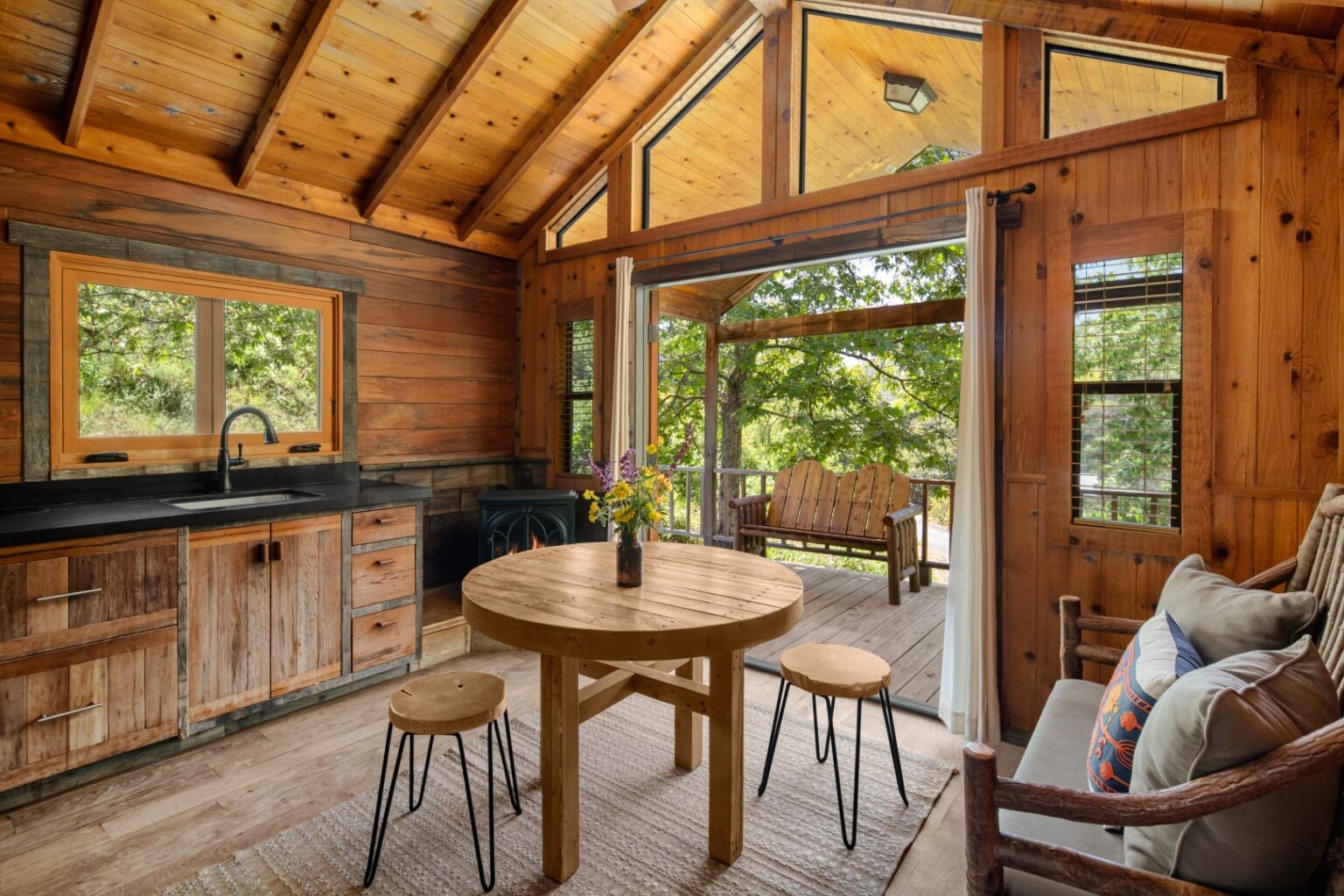image Dine and relax in a stunning open-concept space, where vaulted ceilings and large windows bring the beauty of nature indoors.