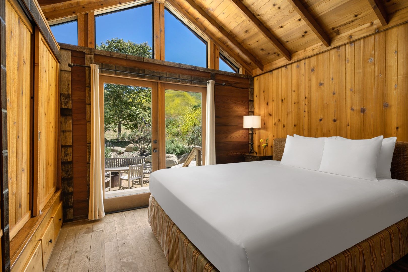 image Wake up to breathtaking views and natural light in this cozy cabin bedroom, where nature meets comfort.