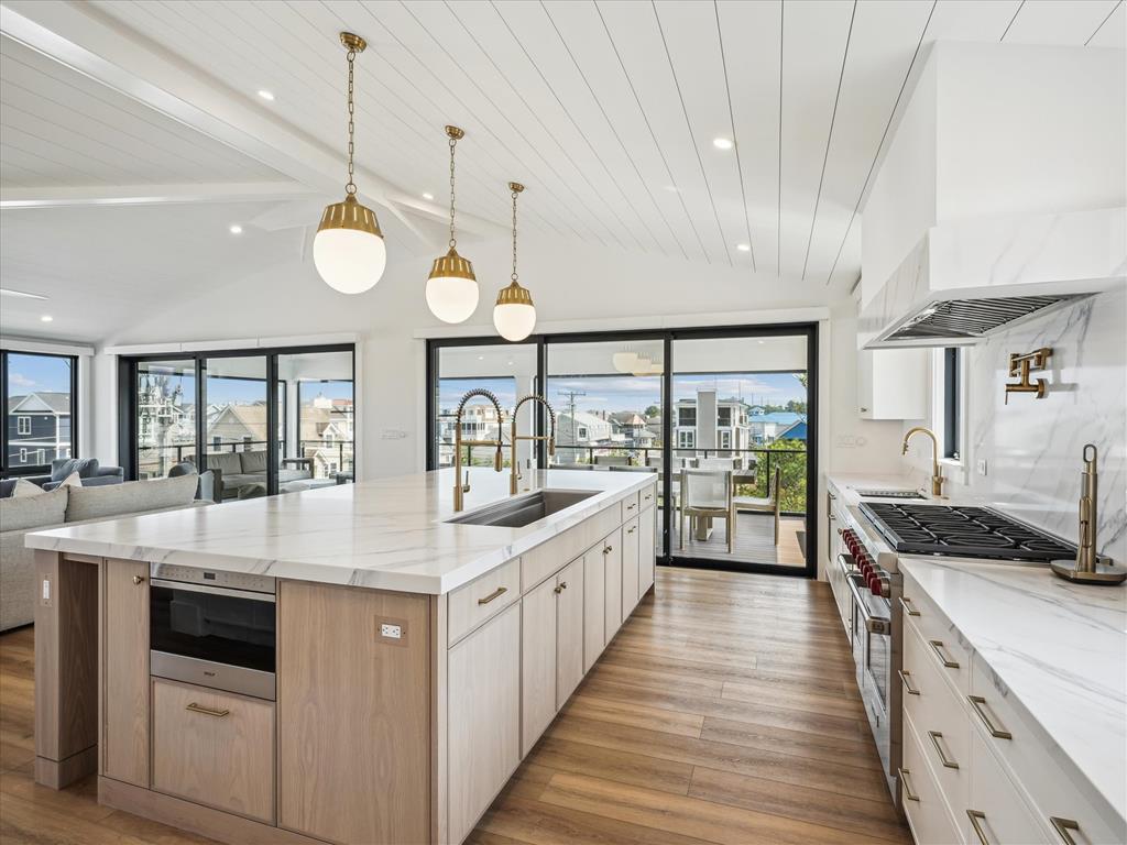 image The spacious kitchen island, complete with a modern sink and high-end finishes, seamlessly connects the culinary and living areas while offering access to outdoor decks.