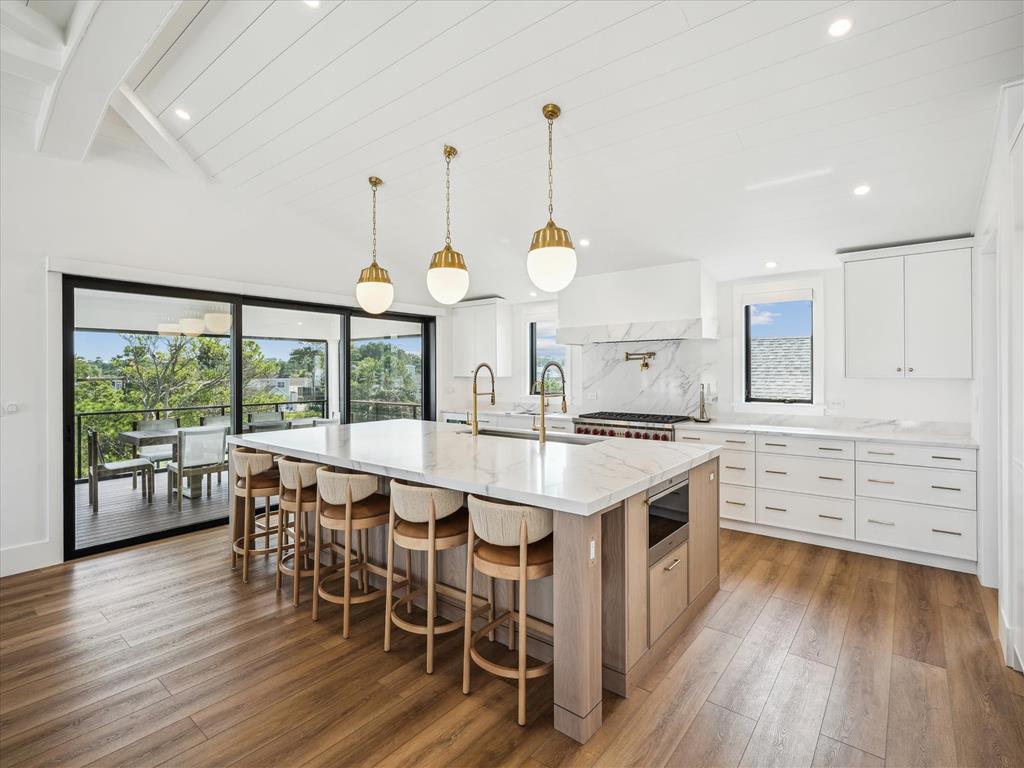 image Showcasing a stylish layout, this kitchen offers breathtaking views from its large glass doors, combining modern charm with a seamless connection to outdoor dining.