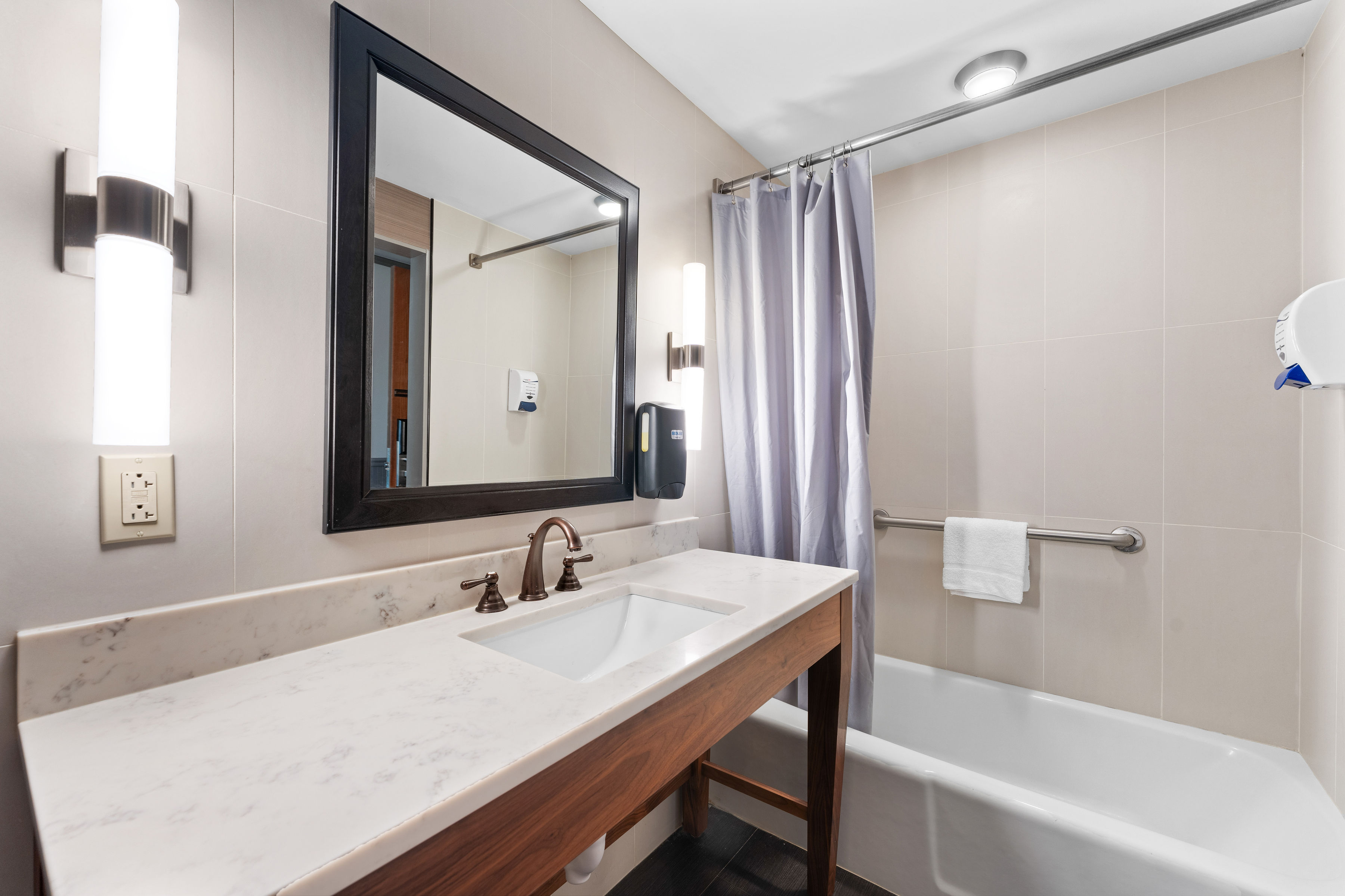image Spacious bathroom with a full vanity and bathtub, offering comfort and convenience.
