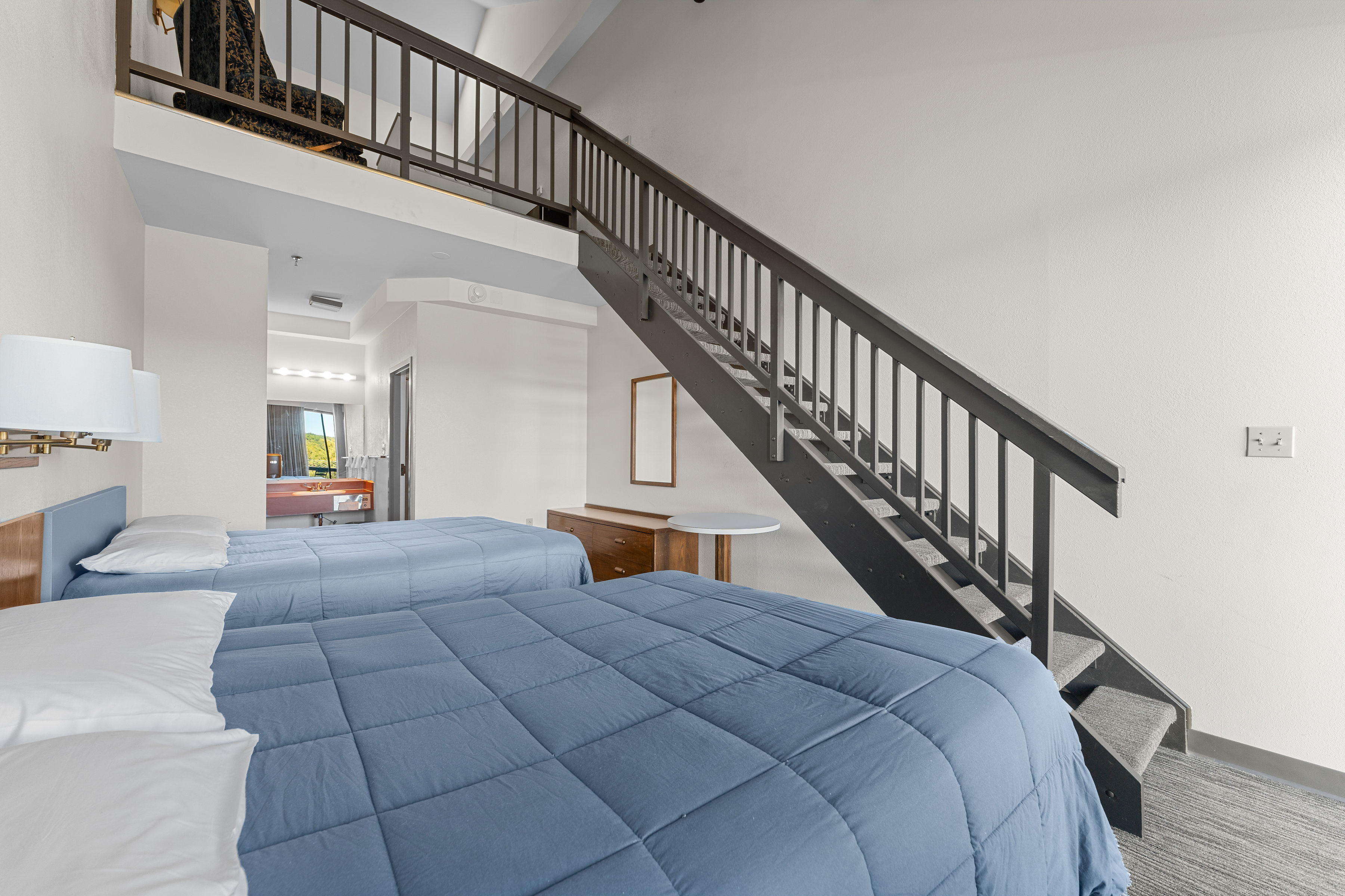 image Cozy and spacious loft-style room with plush queen beds, offering comfort and relaxation after a day of adventure.