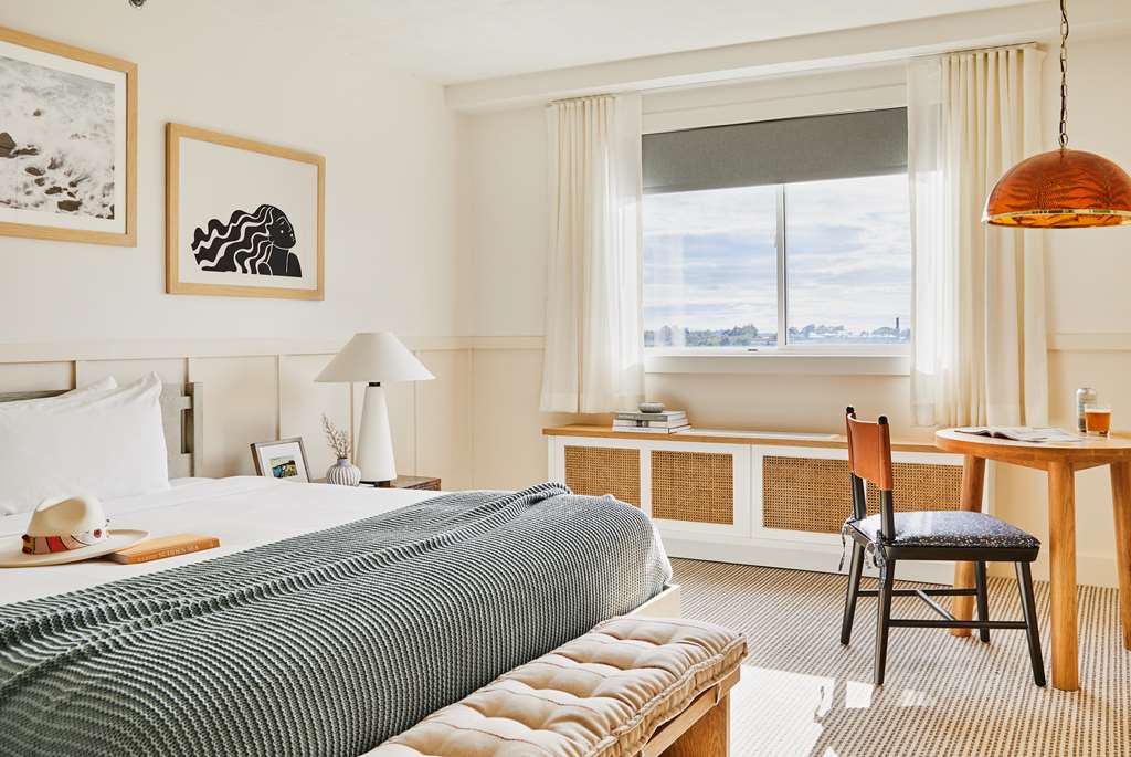 image Embrace serenity with the elegantly decorated king bed complemented by unique artwork and a cozy seating space.