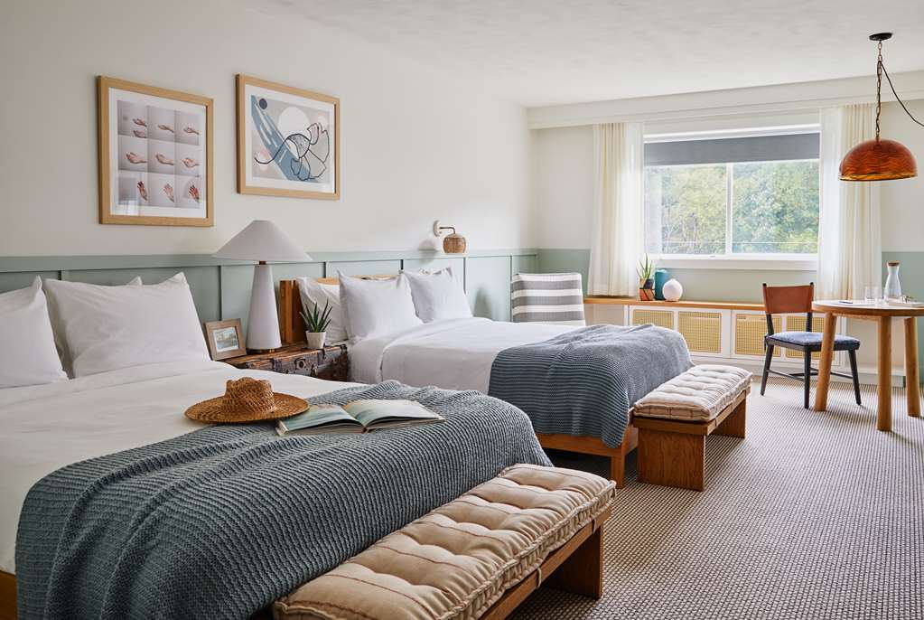 image This Two Queen Parlor Suite showcases two plush queen beds and a cozy seating area, adorned with local art that adds a unique touch.