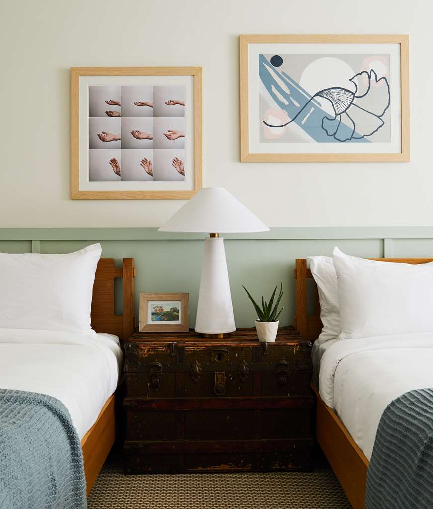 image A charming nightstand complements the two queen beds, accented by local artwork and natural elements, fostering a tranquil ambiance.