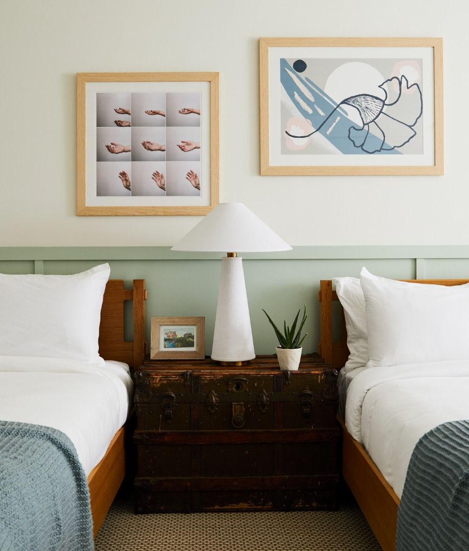 image The cozy ambiance of the room is enhanced by the two queen beds and unique local artwork, creating a warm and inviting atmosphere.