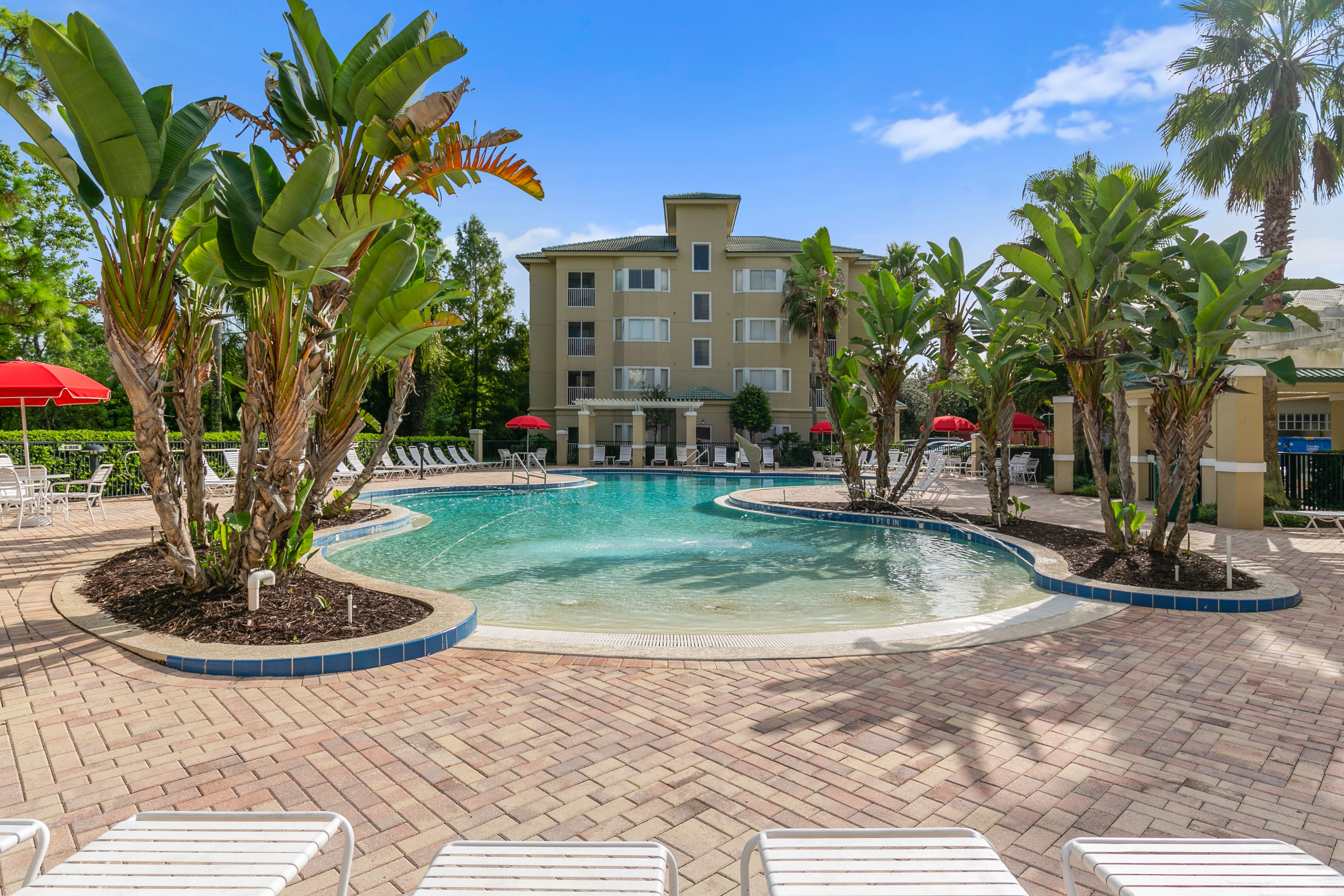 image Dive into relaxation at this beautiful pool area surrounded by lush greenery and inviting lounge chairs, perfect for soaking up the sun and enjoying the tranquil atmosphere.