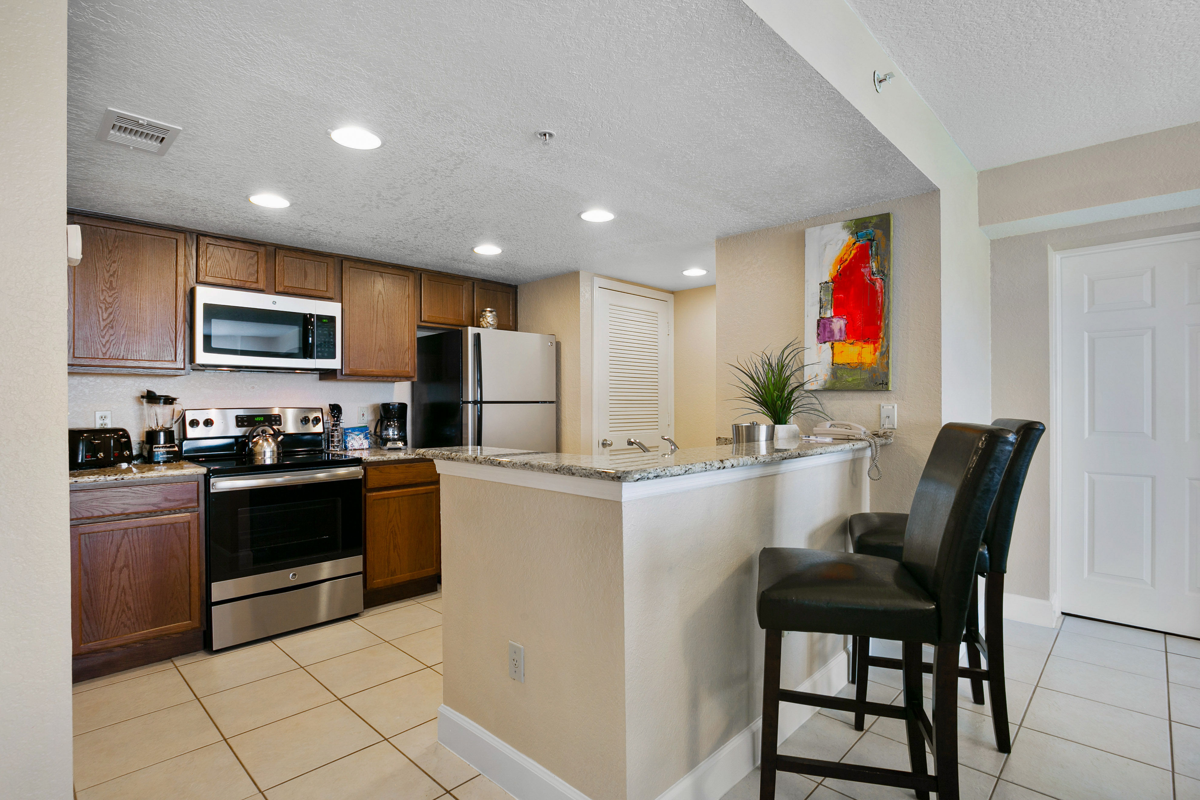 image Cooking is a breeze in this fully equipped kitchen, complete with stainless steel appliances and a spacious granite countertop for dining.