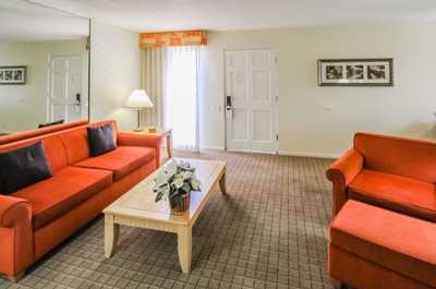 The inviting living area of this two-bedroom condo features vibrant orange sofas and plenty of natural light, perfect for relaxation after a day in the desert.