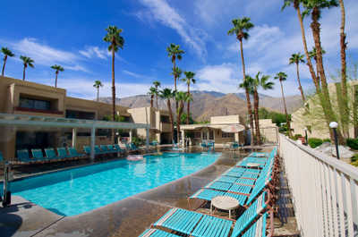 Unwind at the resort pool surrounded by palm trees and mountains, with access to a shared hot tub and relaxing outdoor amenities.