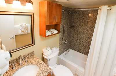 The well-appointed bathroom includes elegant granite finishes and a shower/tub combination, ensuring convenience and comfort for guests with accessible amenities.