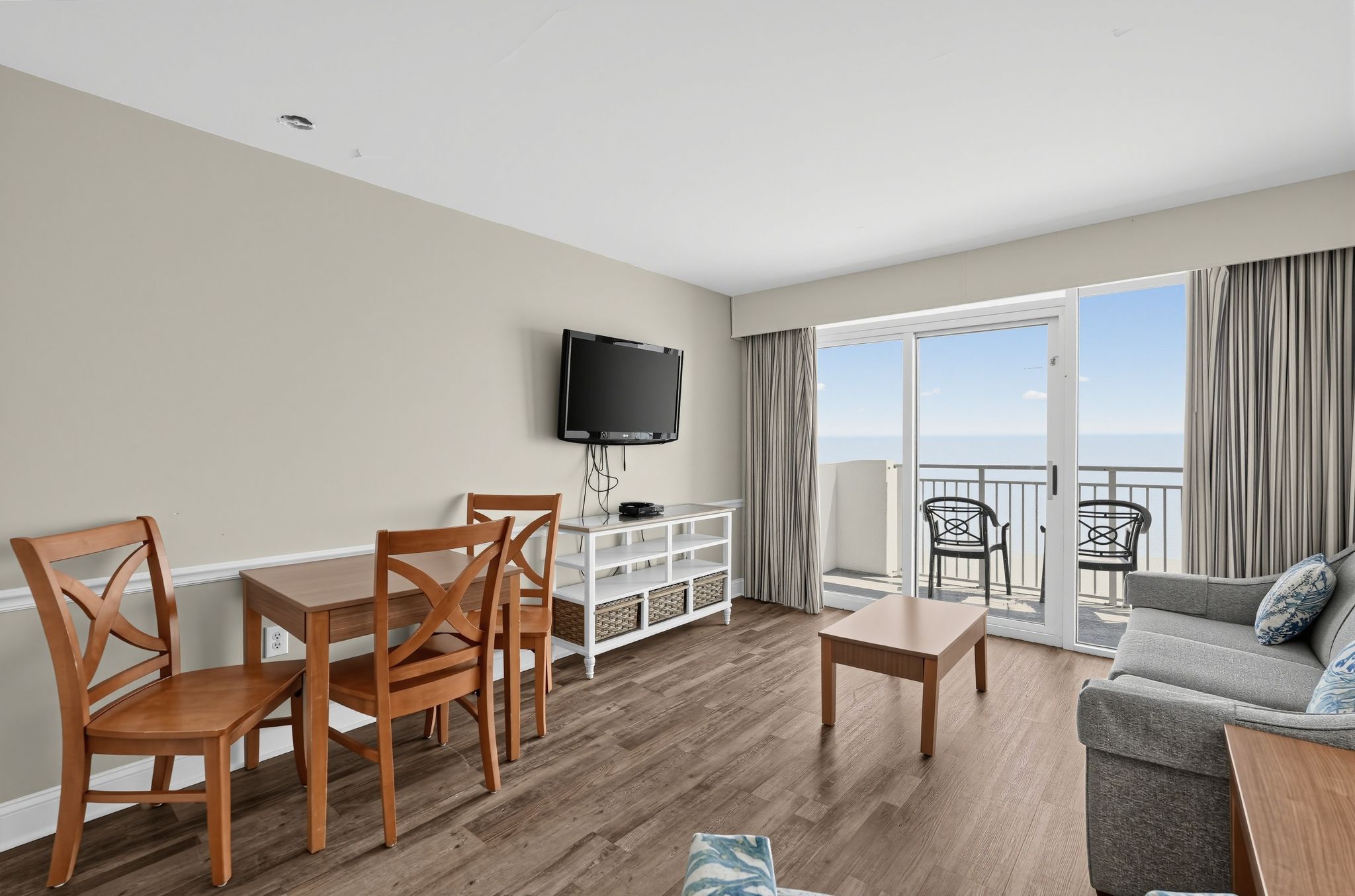 image Living area with sofa, dining table, TV, and ocean view