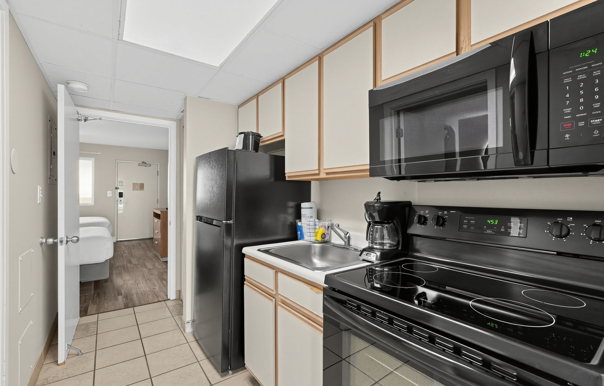 image Kitchen area with black appliances and tiled flooring