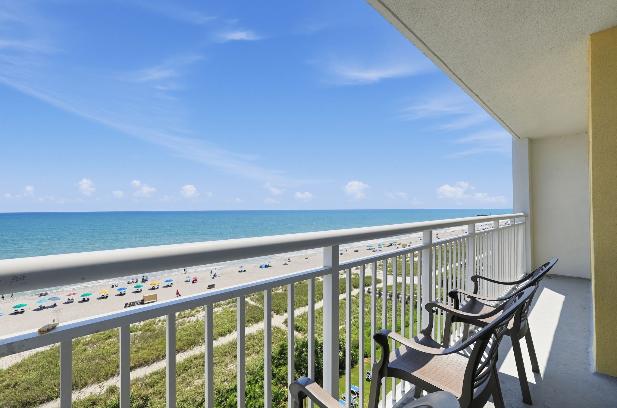 image Balcony overlooking beach and ocean with chairs