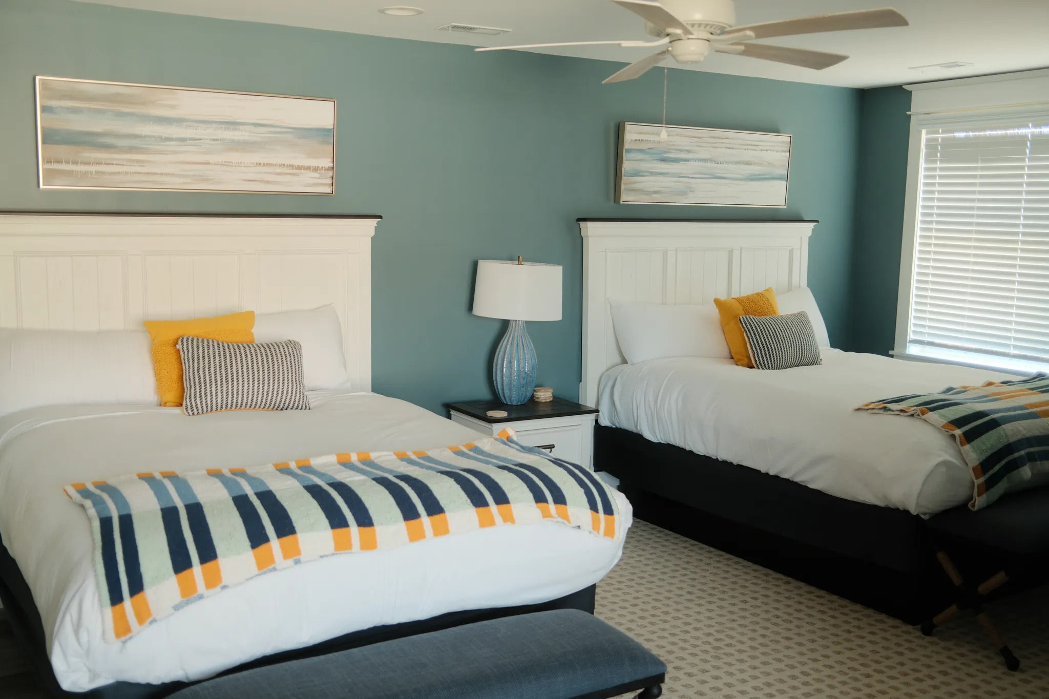 image Stylish bedroom with cool tones and queen beds offers a restful escape for families or friends.