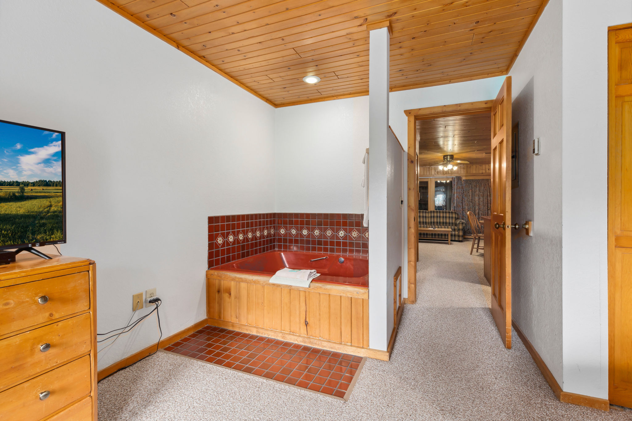 image The inviting corner of the bedroom features a soaking tub, complemented by simple yet tasteful decor.