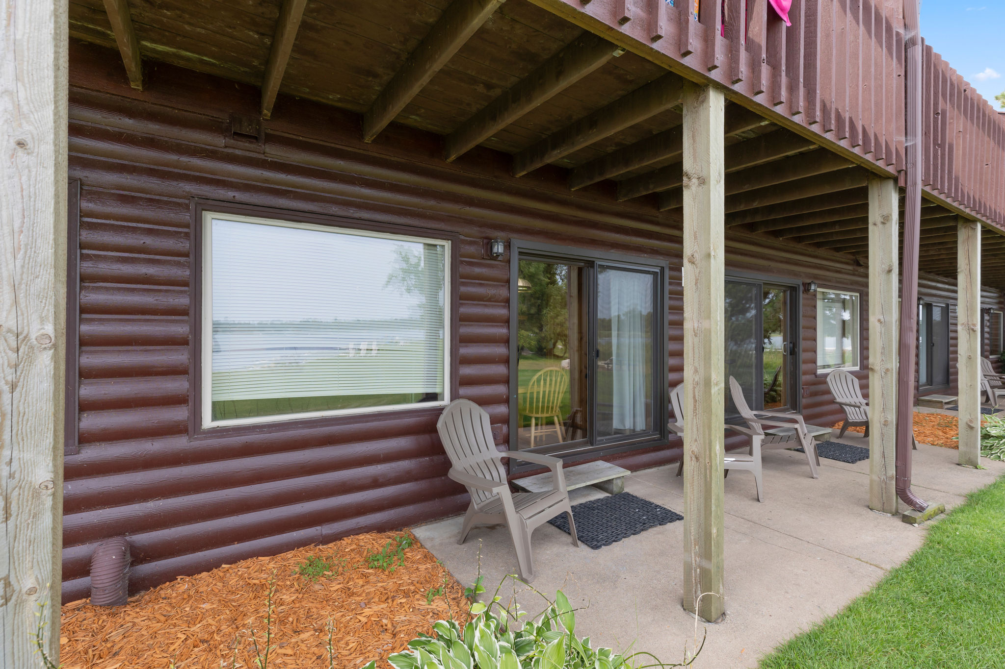 image Covered patio with seating, offering a shaded retreat and views of the lake.
