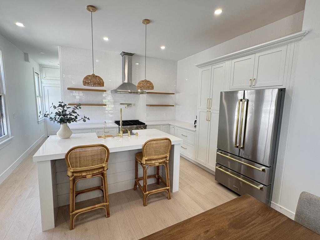 image Sleek, fully equipped kitchen with stainless steel appliances and ample counter space.