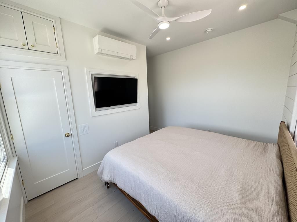 image One of two king bedrooms with built-in storage and wall-mounted TV.
