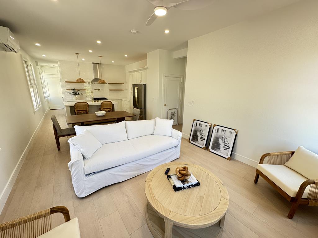 image Modern living room with cozy seating, pull-out couch, and flat-screen TV.
