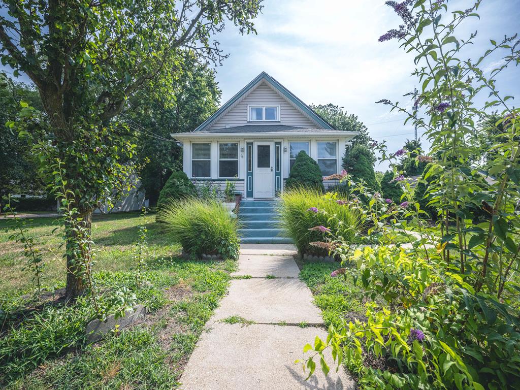image This charming home features a beautifully landscaped front yard with a welcoming pathway leading to the inviting entrance.
