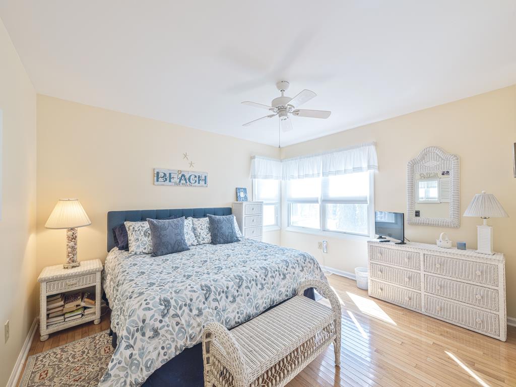 image Bathed in natural light, this spacious bedroom blends coastal elegance with comfort, showcasing beautiful ocean views from its windows.