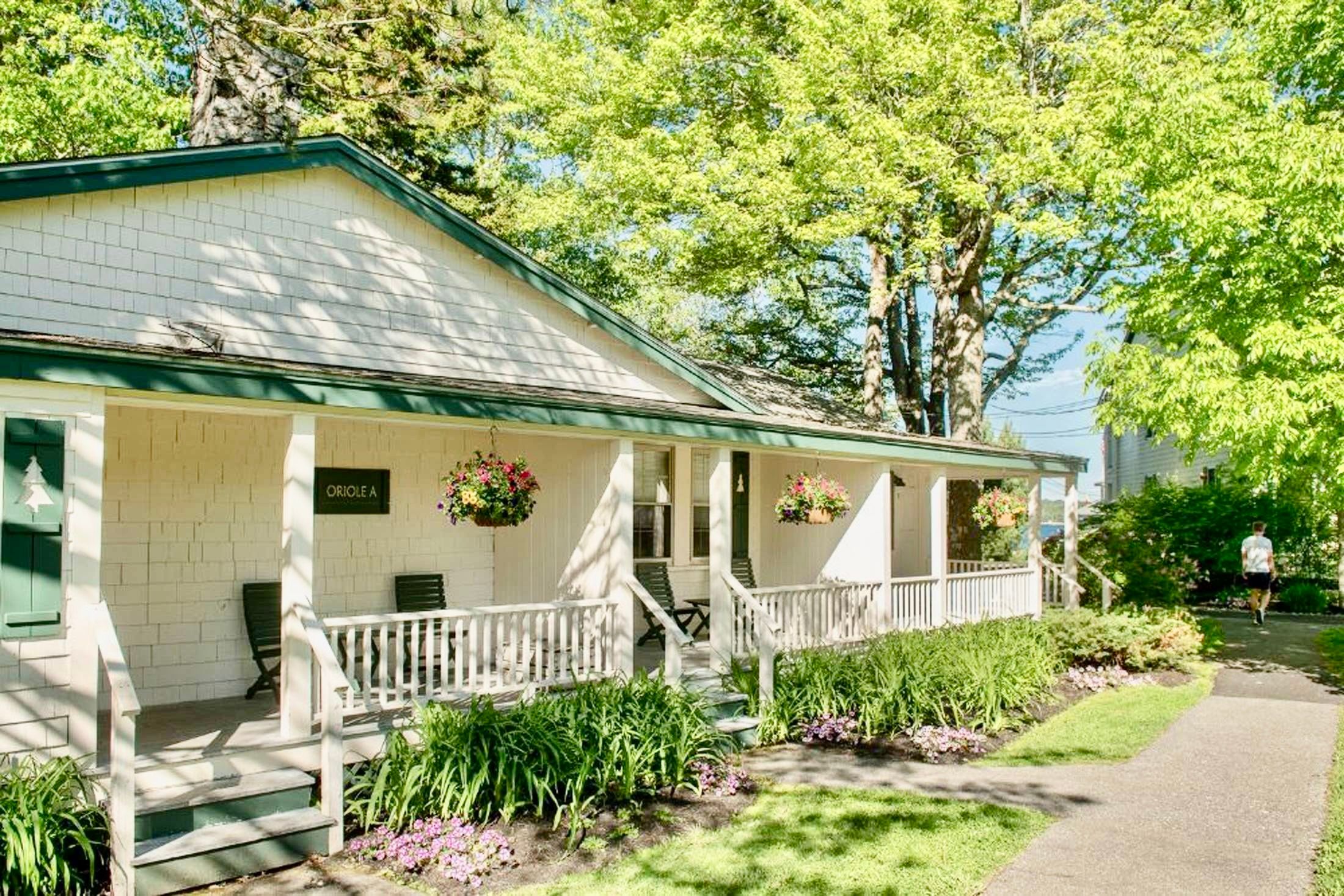 image Wander garden-lined paths to a welcoming cottage porch, where sunny blooms and dappled shade greet you with timeless charm.