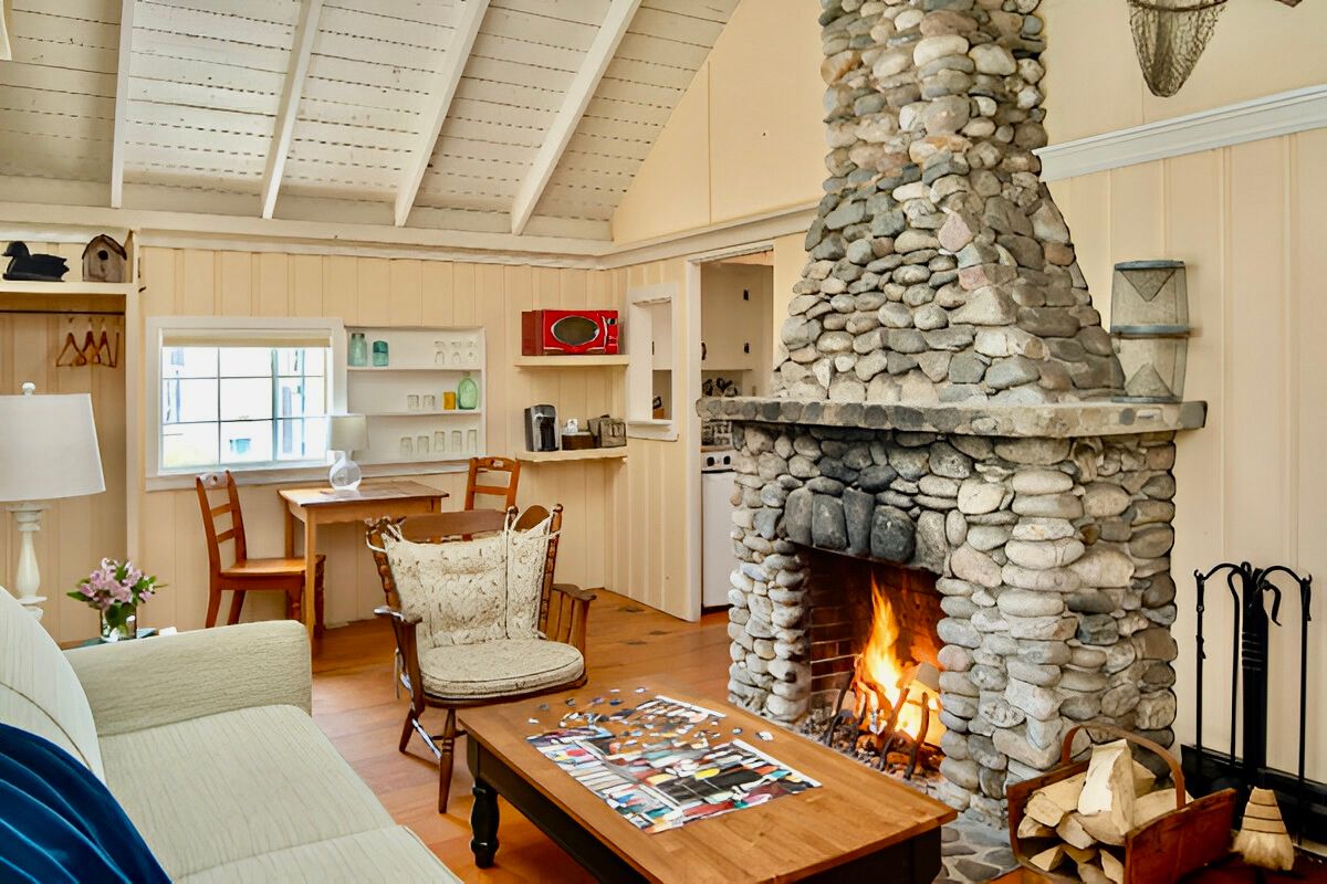 image Gather near the warmth of the stone hearth, where stories are shared beneath lofty ceilings and rustic beams.