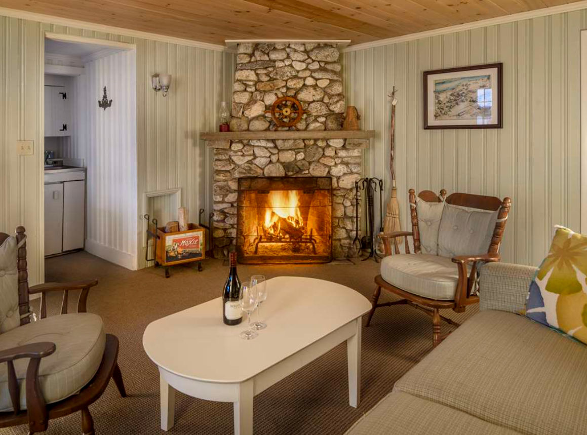 image Settle in by the fire where rustic stone, cozy textures, and a glass of wine invite hours of unwinding.