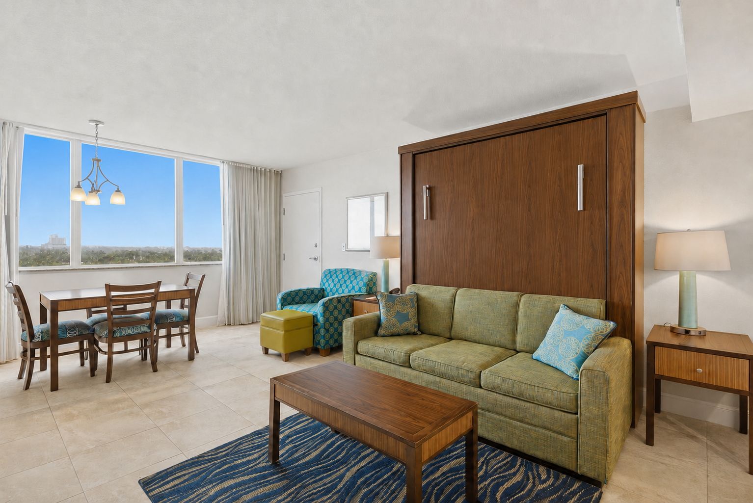 image Living area with seating, dining table, and large windows