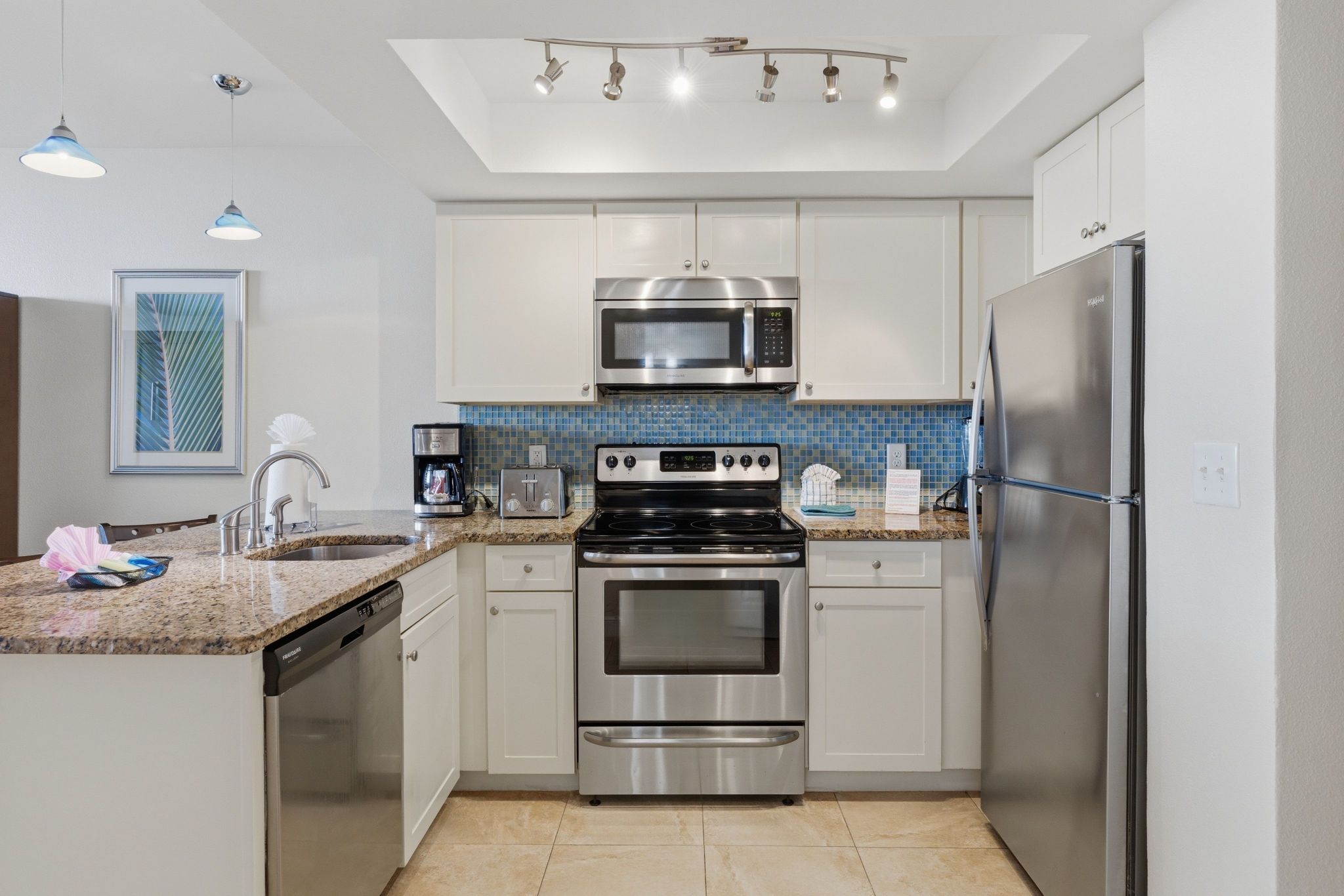 image Kitchen area with stove, microwave, and countertops