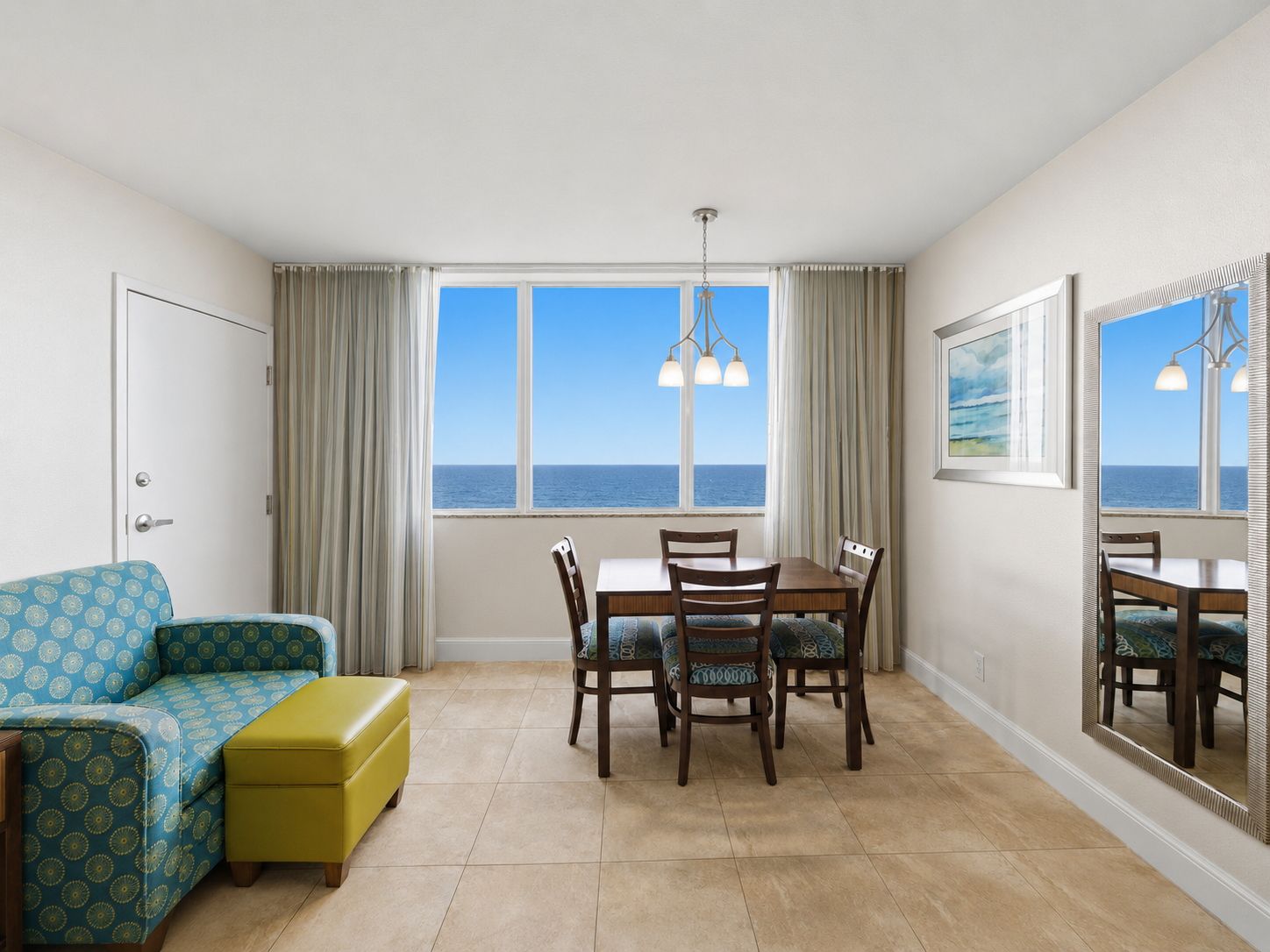 image Living area with couch, dining table, and ocean view