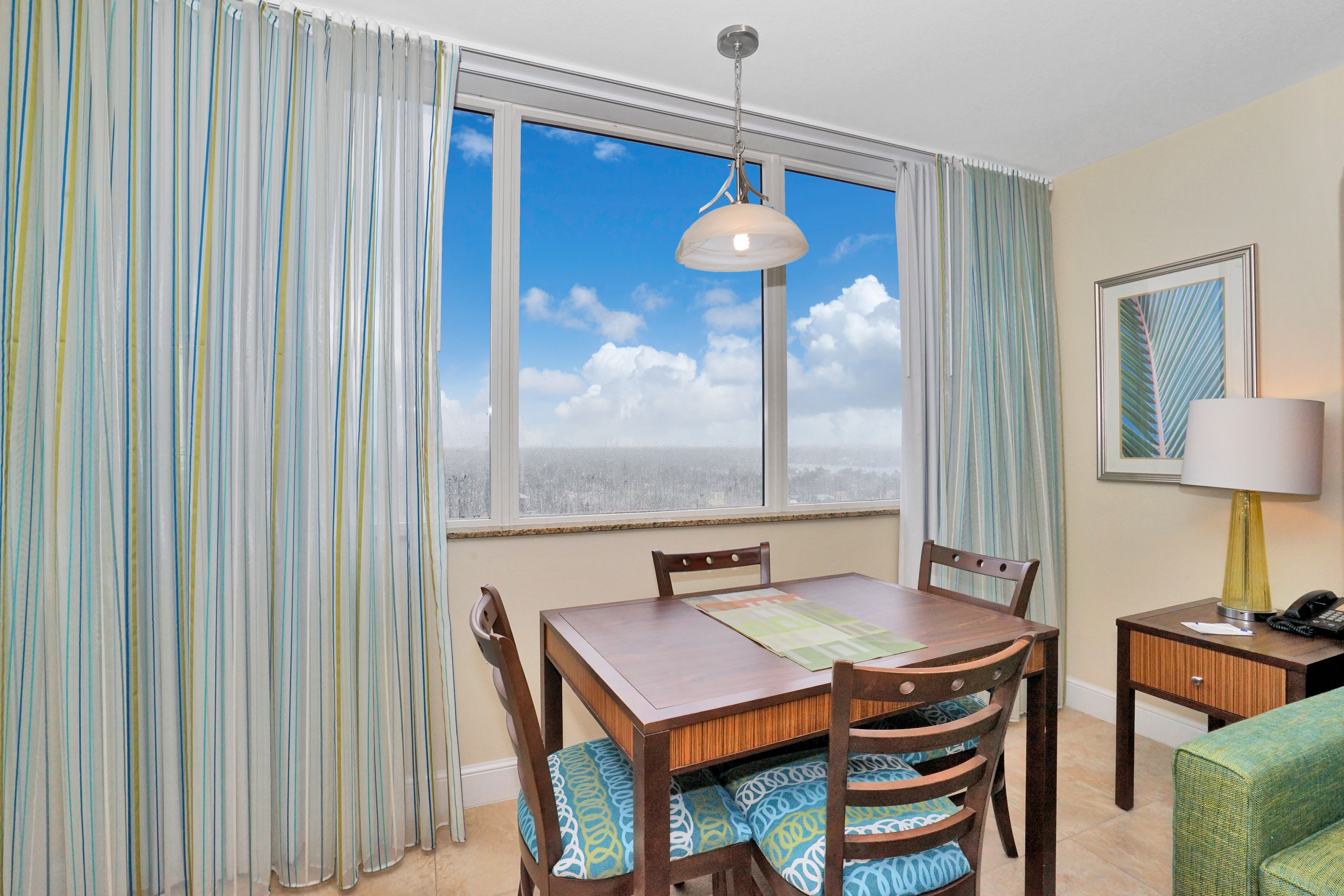 image Dining Area: Wooden table with patterned chairs and pendant light, with a view from the window.