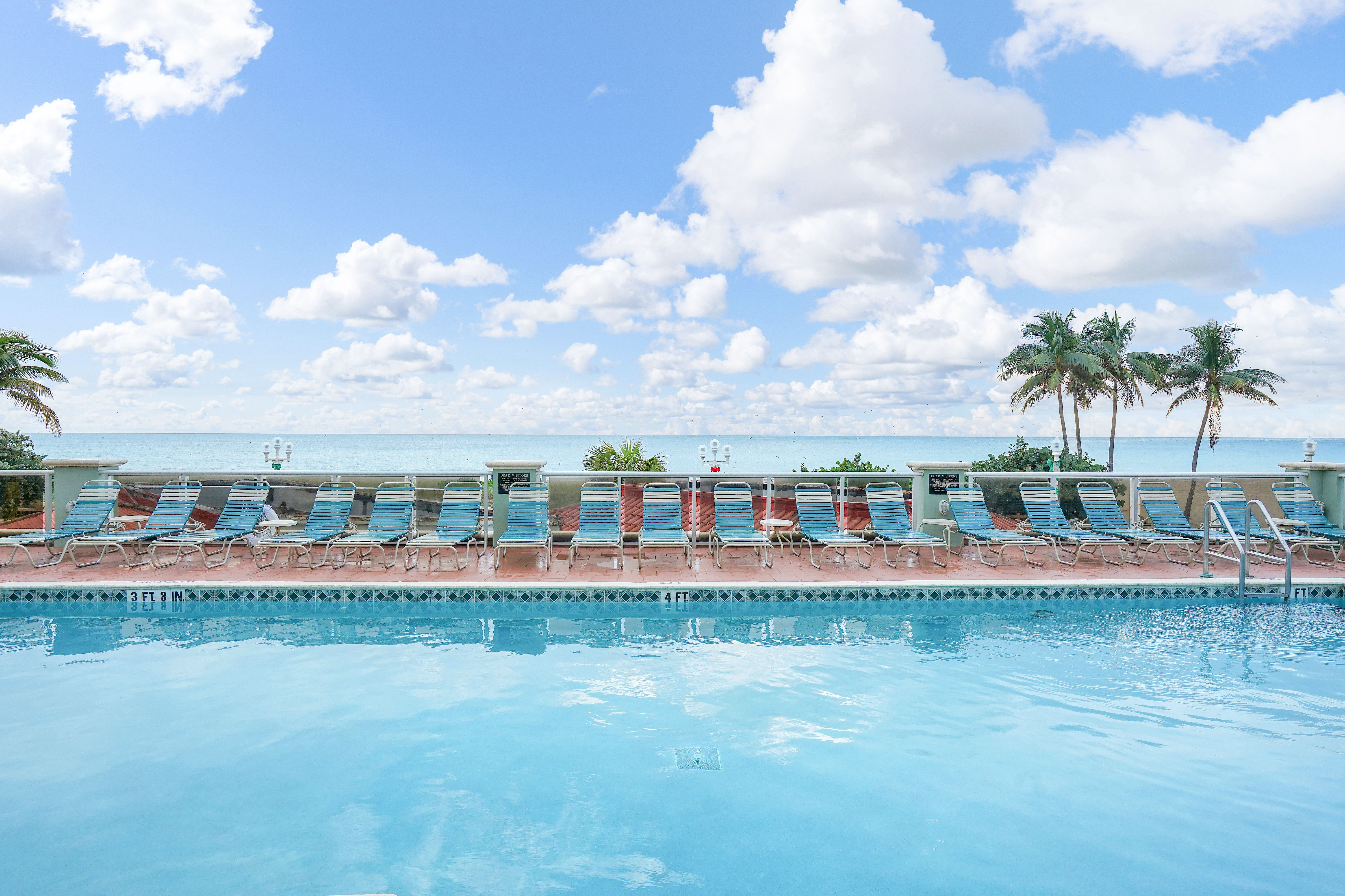 image Swimming Pool Area: Poolside setting with lounge chairs facing the ocean.