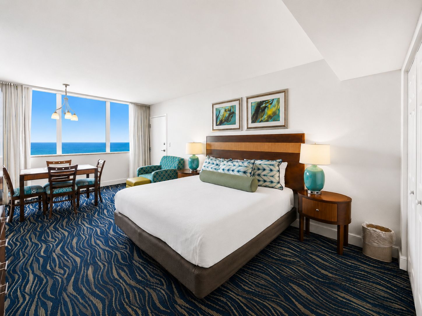 image Studio sleeping area with king bed, dining table, and ocean view.
