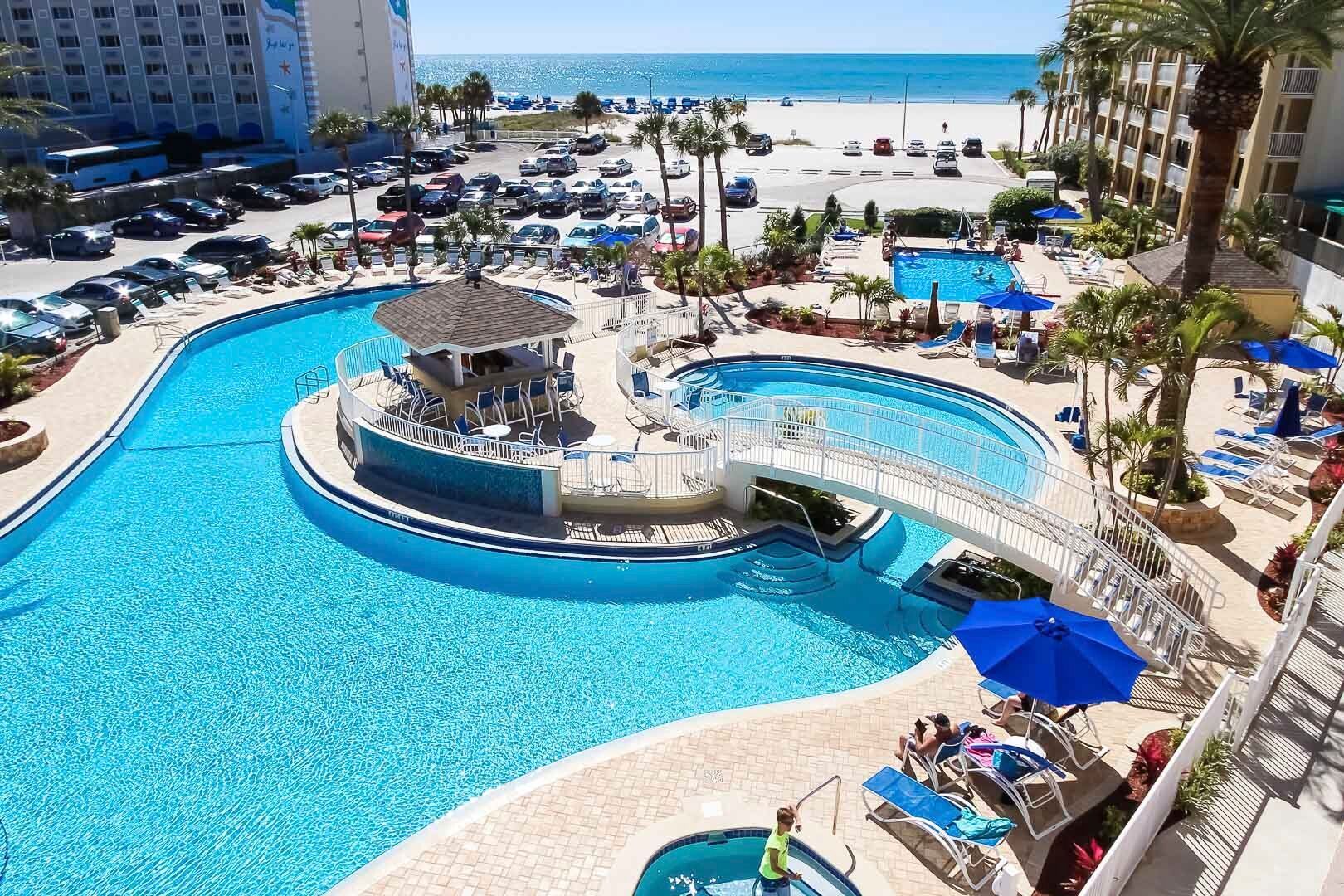 image Discover the inviting pool area complete with a waterfall and a connecting bridge while enjoying direct beach access, perfect for family fun and relaxation.