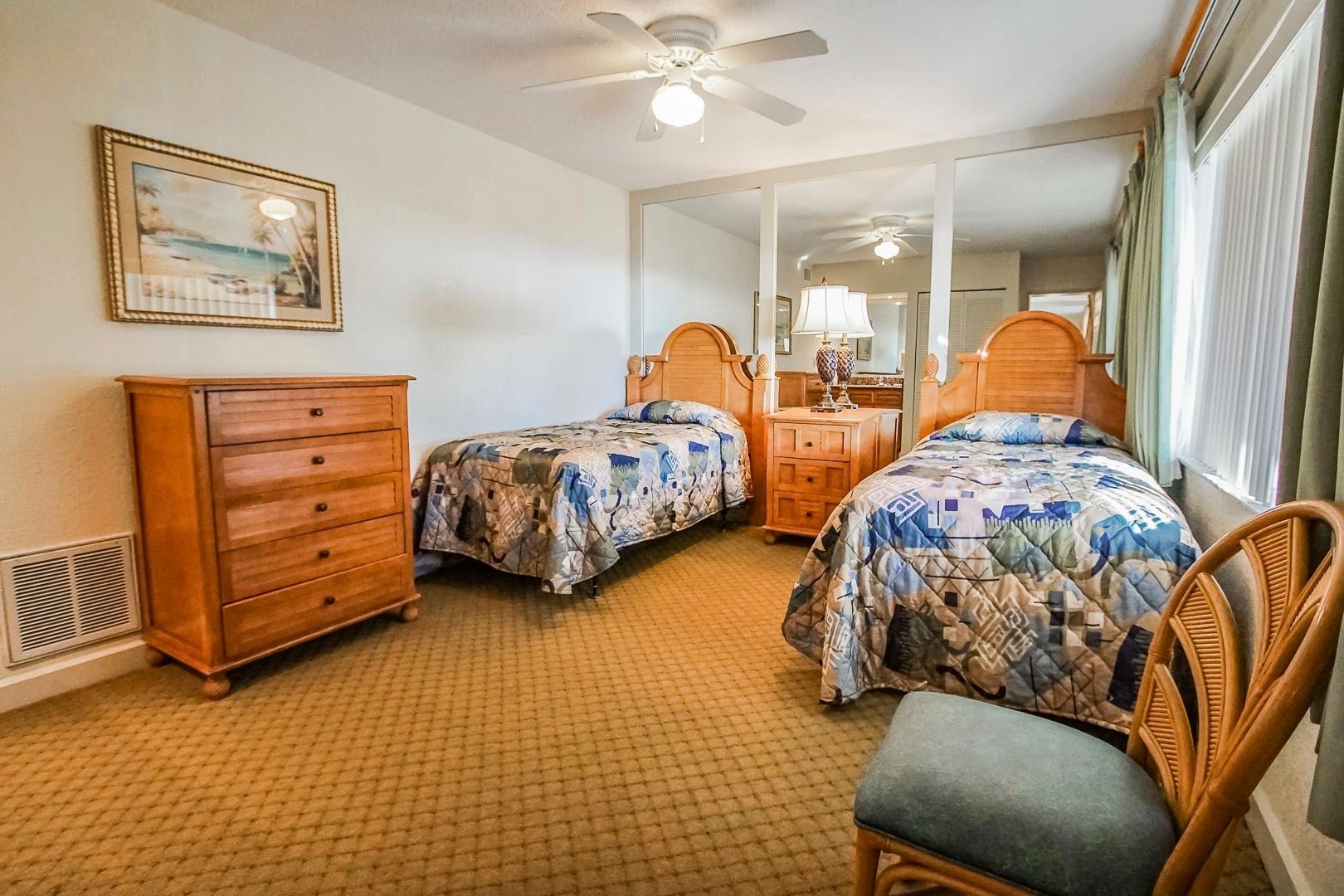 image This cozy bedroom features two twin beds with colorful bedding, a wooden dresser, and ample natural light.