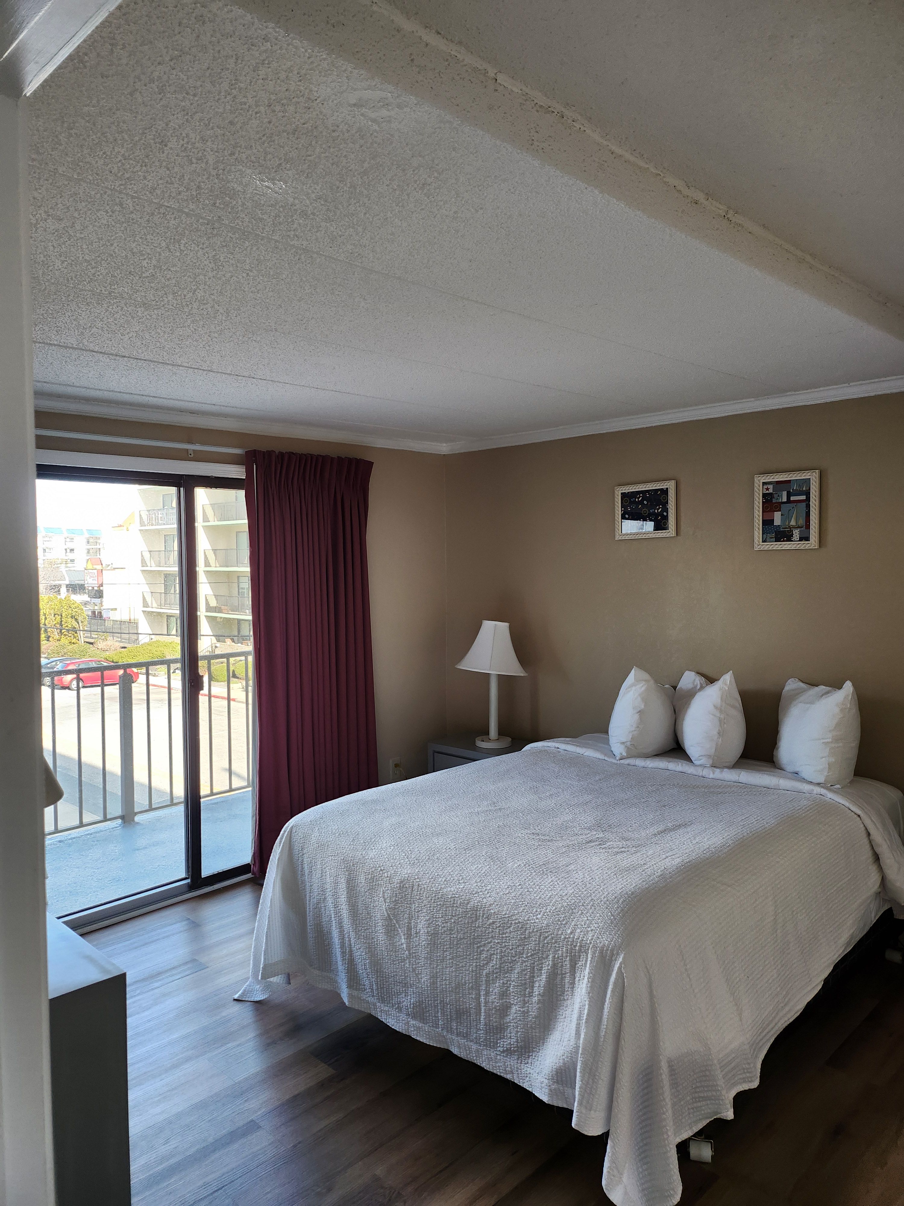 image Retreat to a cozy bedroom with direct balcony access, ideal for unwinding and enjoying the sea breeze.