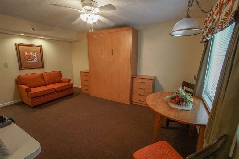 image Experience cozy living with a queen Murphy bed, a loveseat for lounging, and a dining table for two in your beachside retreat!