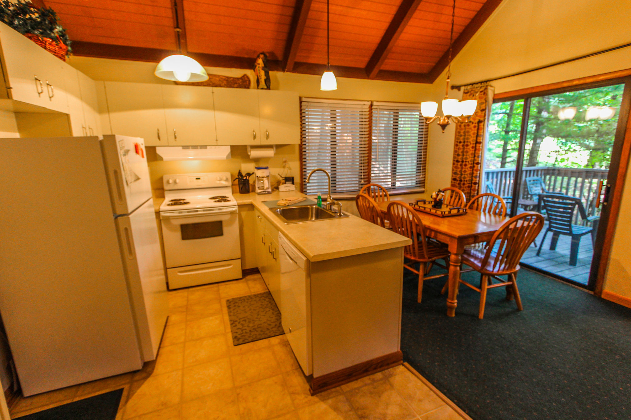 image The cozy and fully equipped kitchen features a dining area that opens up to a private deck, perfect for a peaceful family retreat.