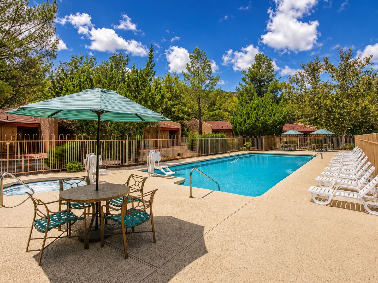 image A bright and inviting outdoor pool area surrounded by lush greenery and lounge chairs, perfect for family fun and relaxation in the Sedona sun.