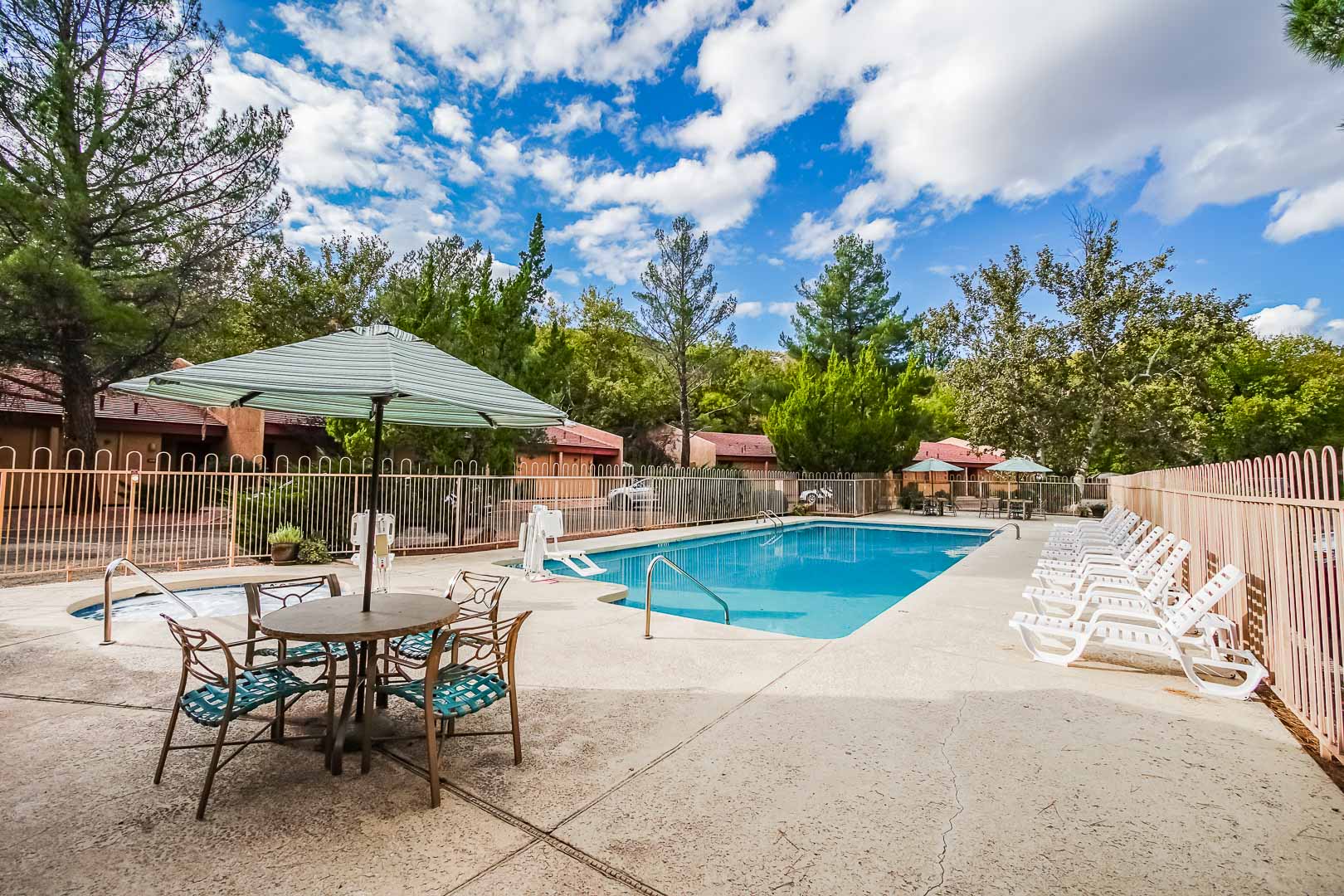 image A bright and inviting outdoor pool area surrounded by lush greenery and lounge chairs, perfect for family fun and relaxation in the Sedona sun.
