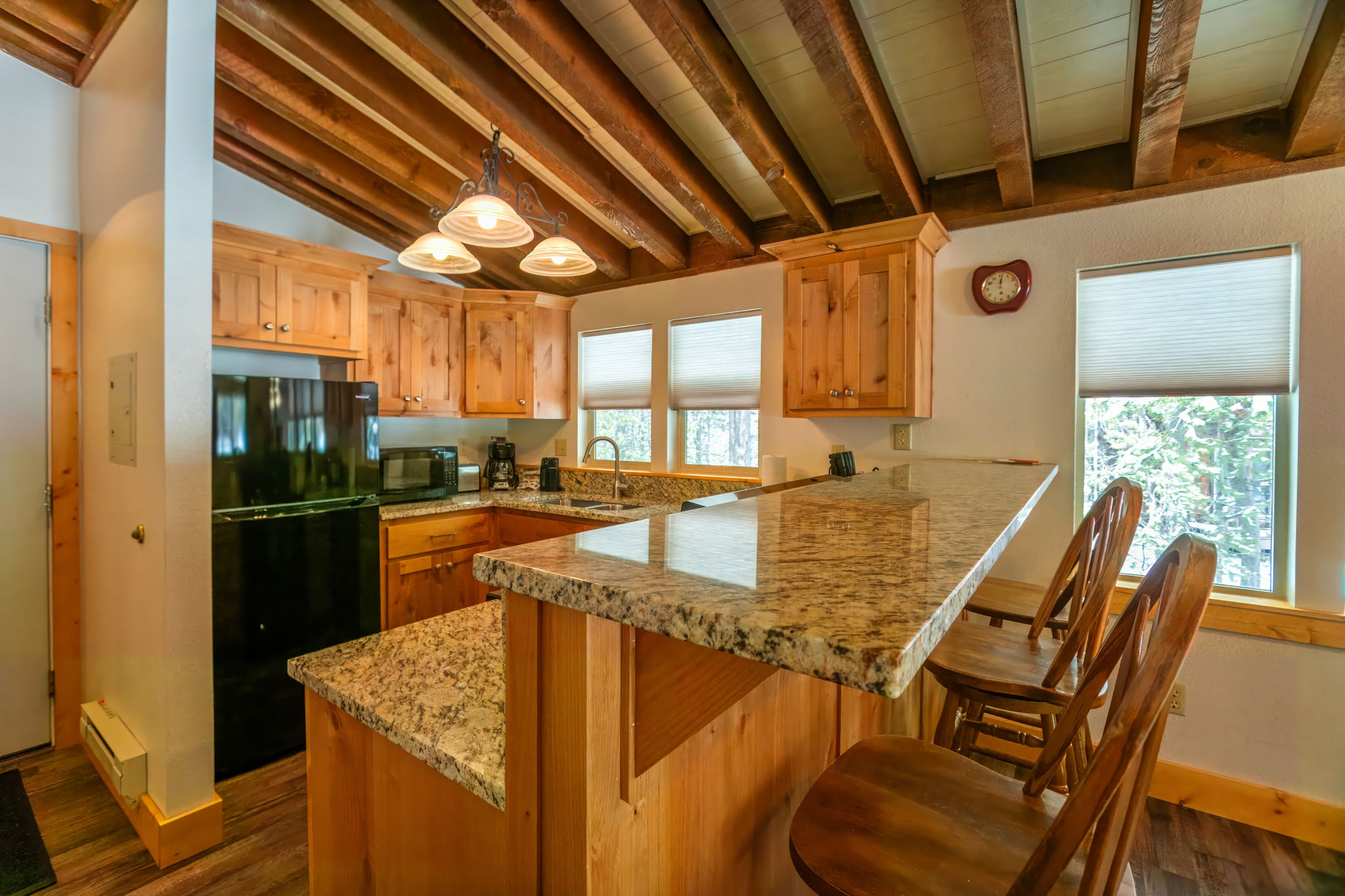 image Enjoy casual breakfasts at the stylish granite breakfast bar, bathed in natural light from the surrounding windows.