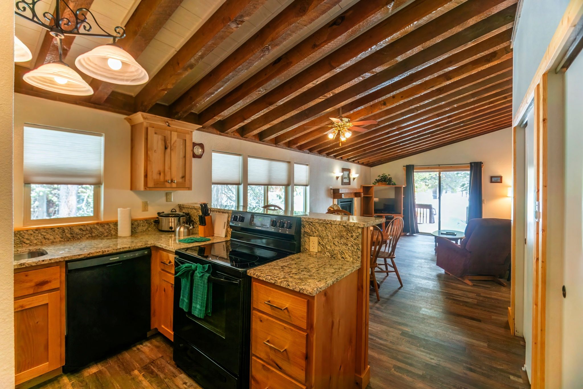 image Experience cozy cooking in a fully equipped kitchen adorned with wooden beams, perfect for family meals and gatherings.