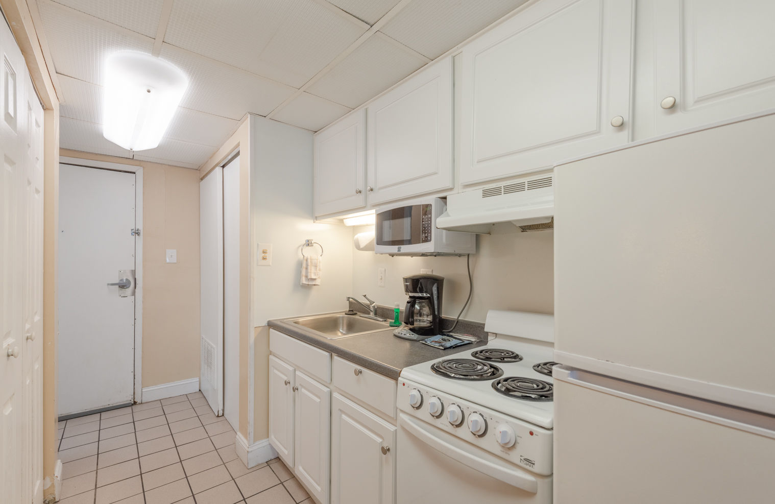 image The functional full kitchen boasts essential appliances, allowing guests to enjoy the comforts of home while on vacation, complemented by nearby laundry facilities.