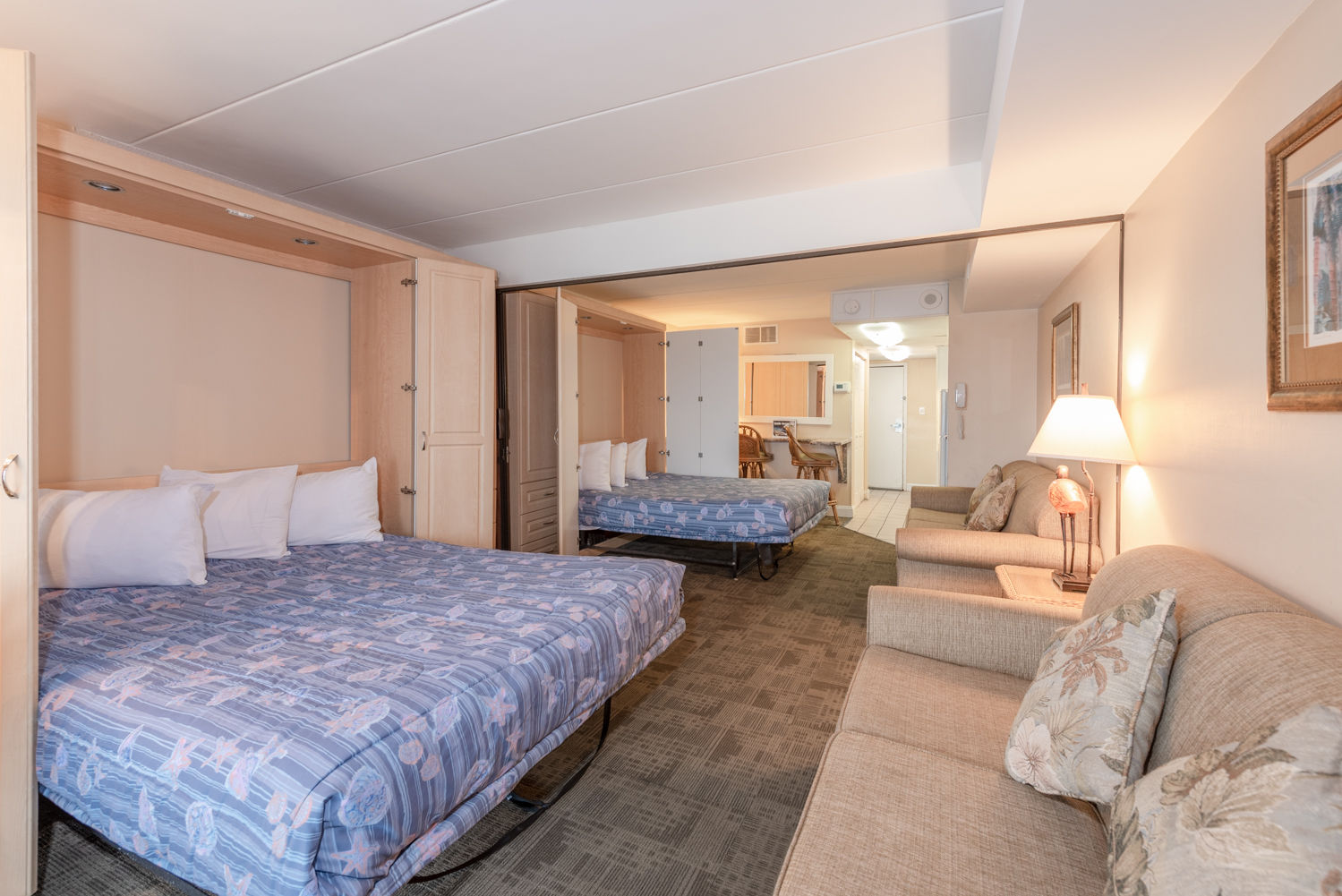 image A cozy room featuring two Queen Murphy beds, perfect for family stays, with a full kitchen and access to an outdoor pool.