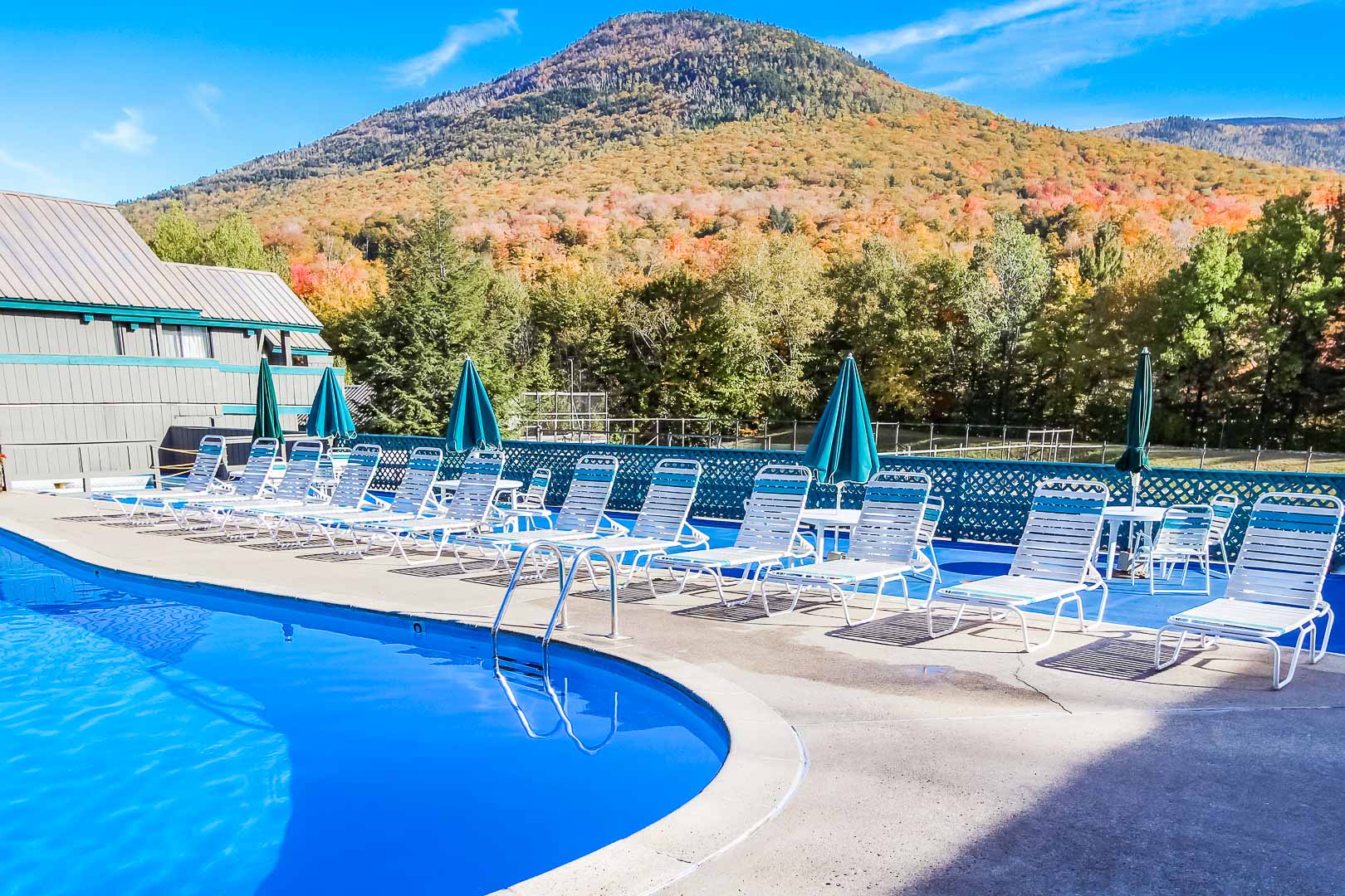 image Enjoy breathtaking mountain views from the expansive outdoor pool area, complete with comfortable lounge chairs by the water’s edge.
